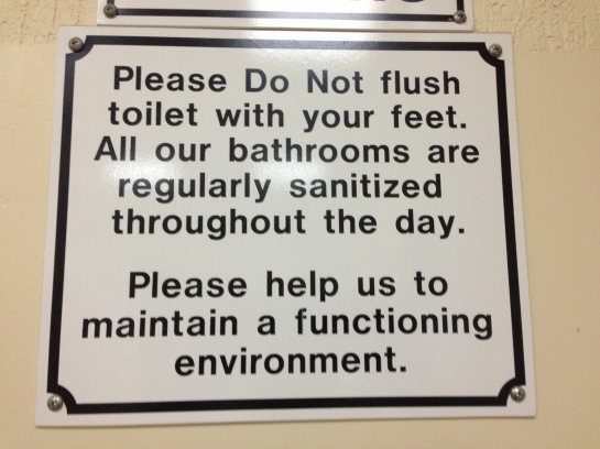 sign in the belize city airport bathroom